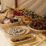 Pueblo rural con feria artesanal, bancarelle colorate e artigiani al lavoro.